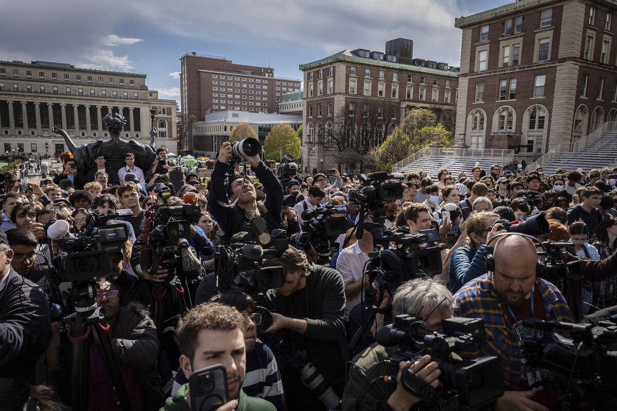 Students and press look on as Speaker of the House Mike Johnson, R-La., speaks to the media on ...