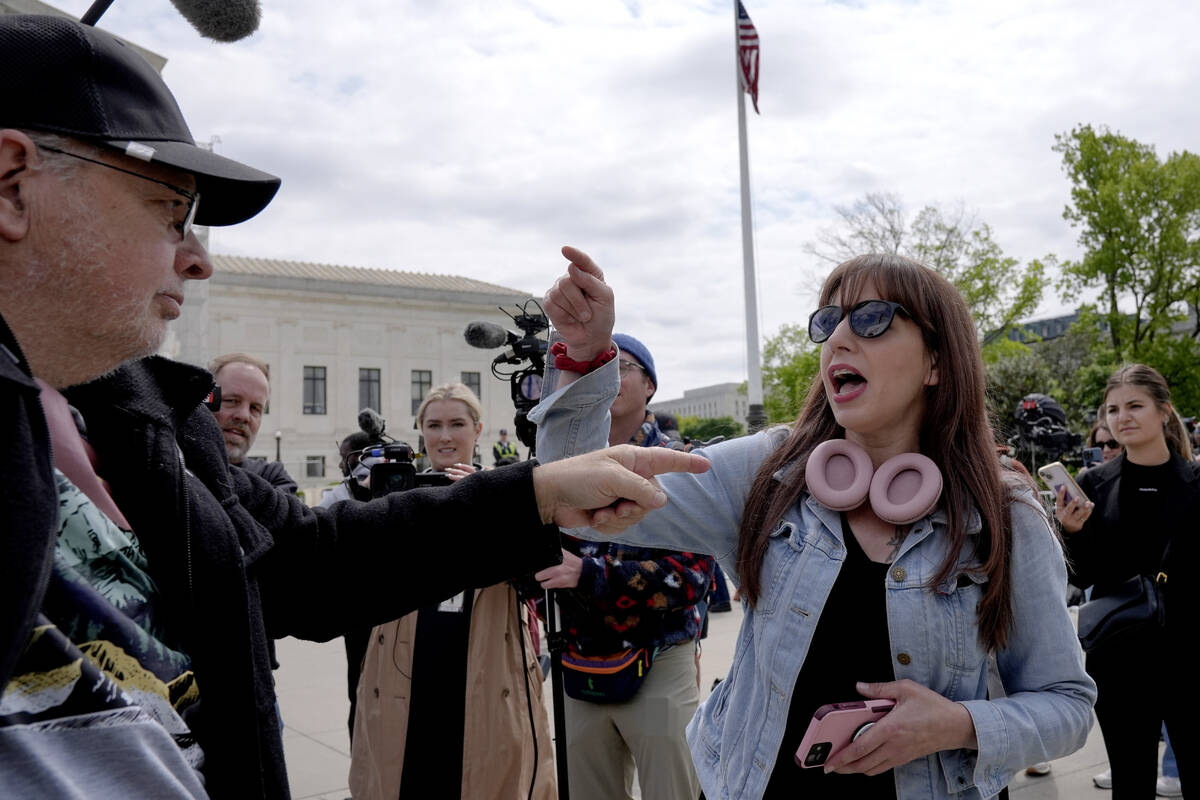 Demonstrators protest outside the Supreme Court as the justices prepare to hear arguments over ...