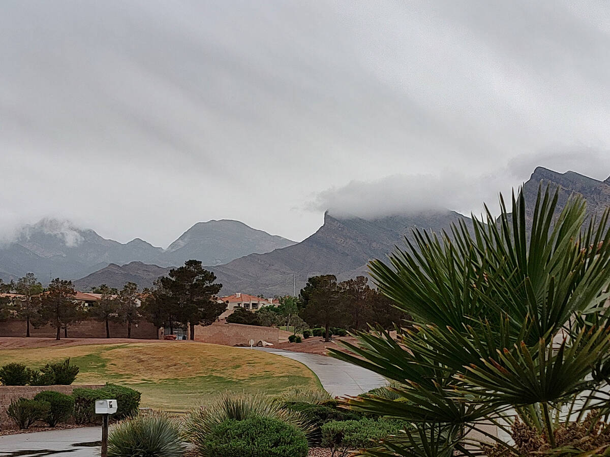 Rain clouds obscure some of the hills on the west side of the Las Vegas Valley shortly before n ...