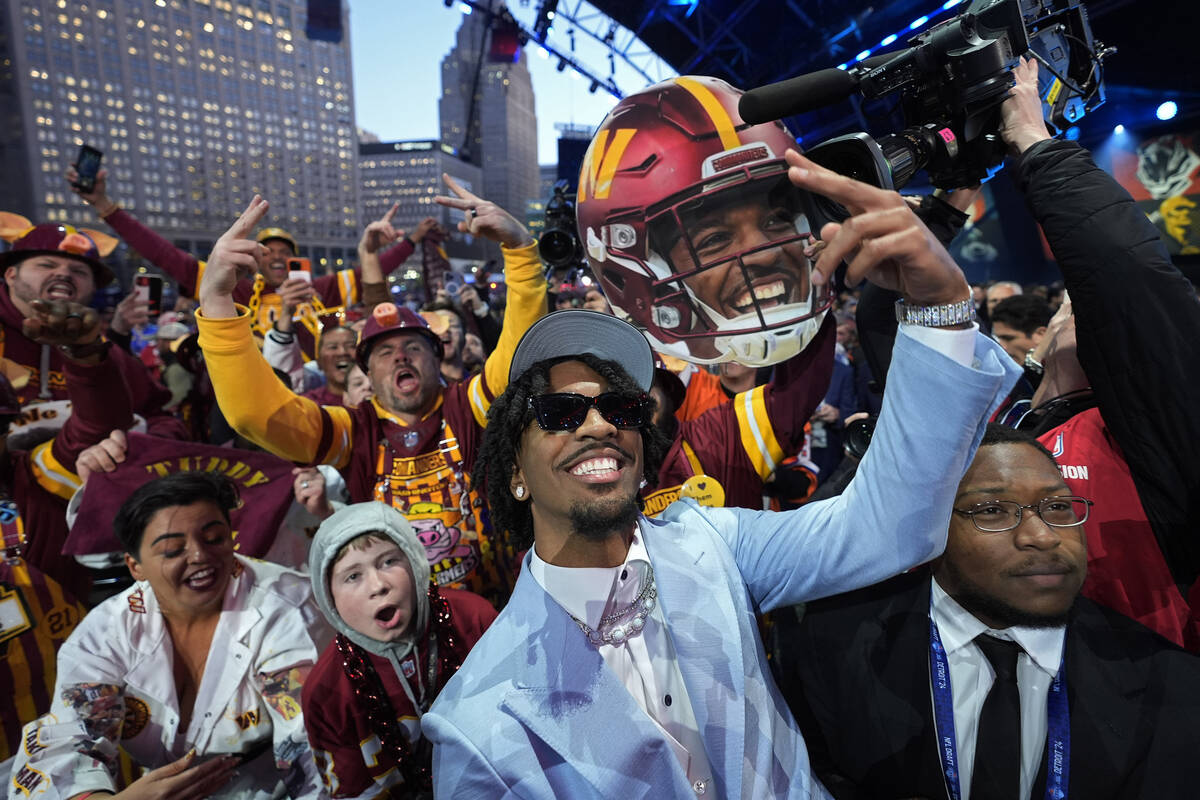 LSU quarterback Jayden Daniels celebrates with fans after being chosen by the Washington Comman ...