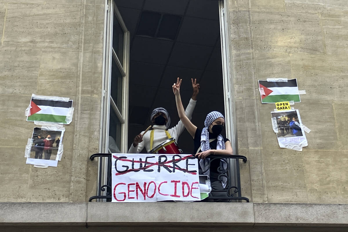 Students blocking the Sciences Po university flash the V sign Friday, April 26, 2024 in Paris. ...