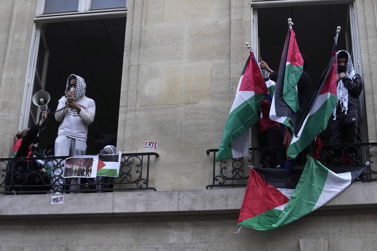 Students blocking Sciences-Po university display Palestinian flags, in Paris Friday, April 26, ...