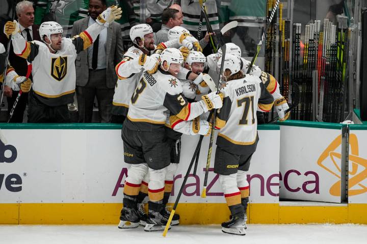 Vegas Golden Knights players celebrate an empty net goal by Jack Eichel, center, during the thi ...