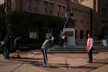 Graduating seniors take photos around the Tommy Trojan statue on the University of Southern Cal ...