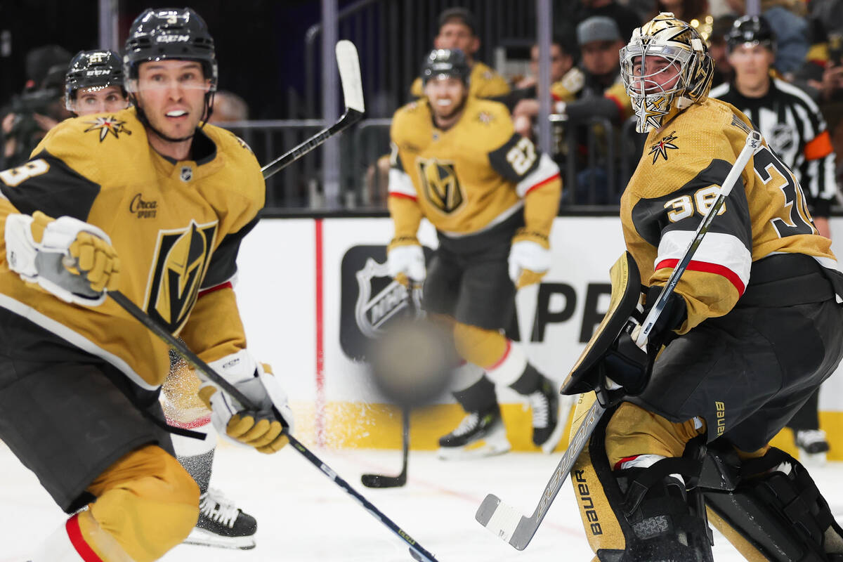 Golden Knights goaltender Logan Thompson (36) and defenseman Brayden McNabb (3) eye the puck du ...