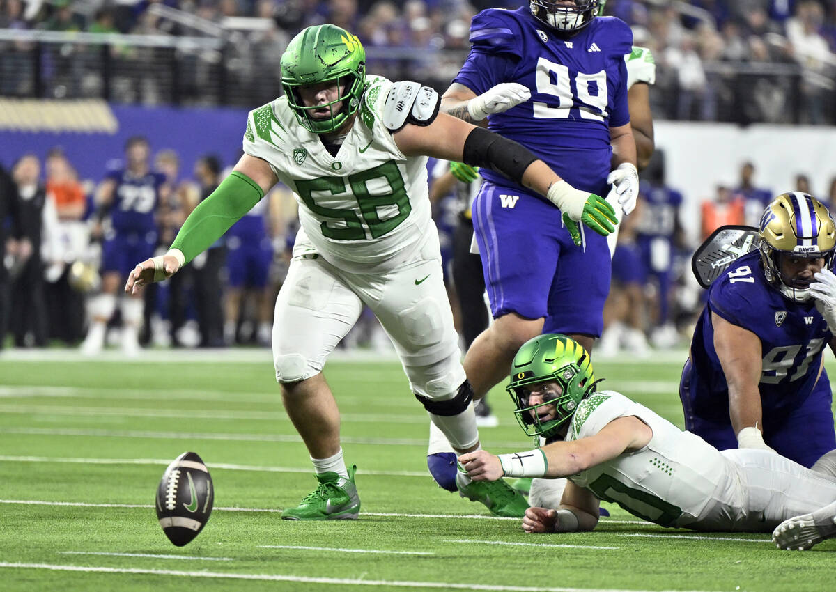 Oregon quarterback Bo Nix (10) and offensive lineman Jackson Powers-Johnson (58) go to cover th ...