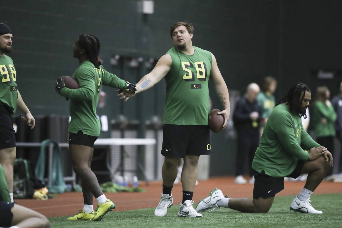 Oregon running back Bucky Irving, left, highfives offensive lineman Jackson Powers-Johnson (58) ...