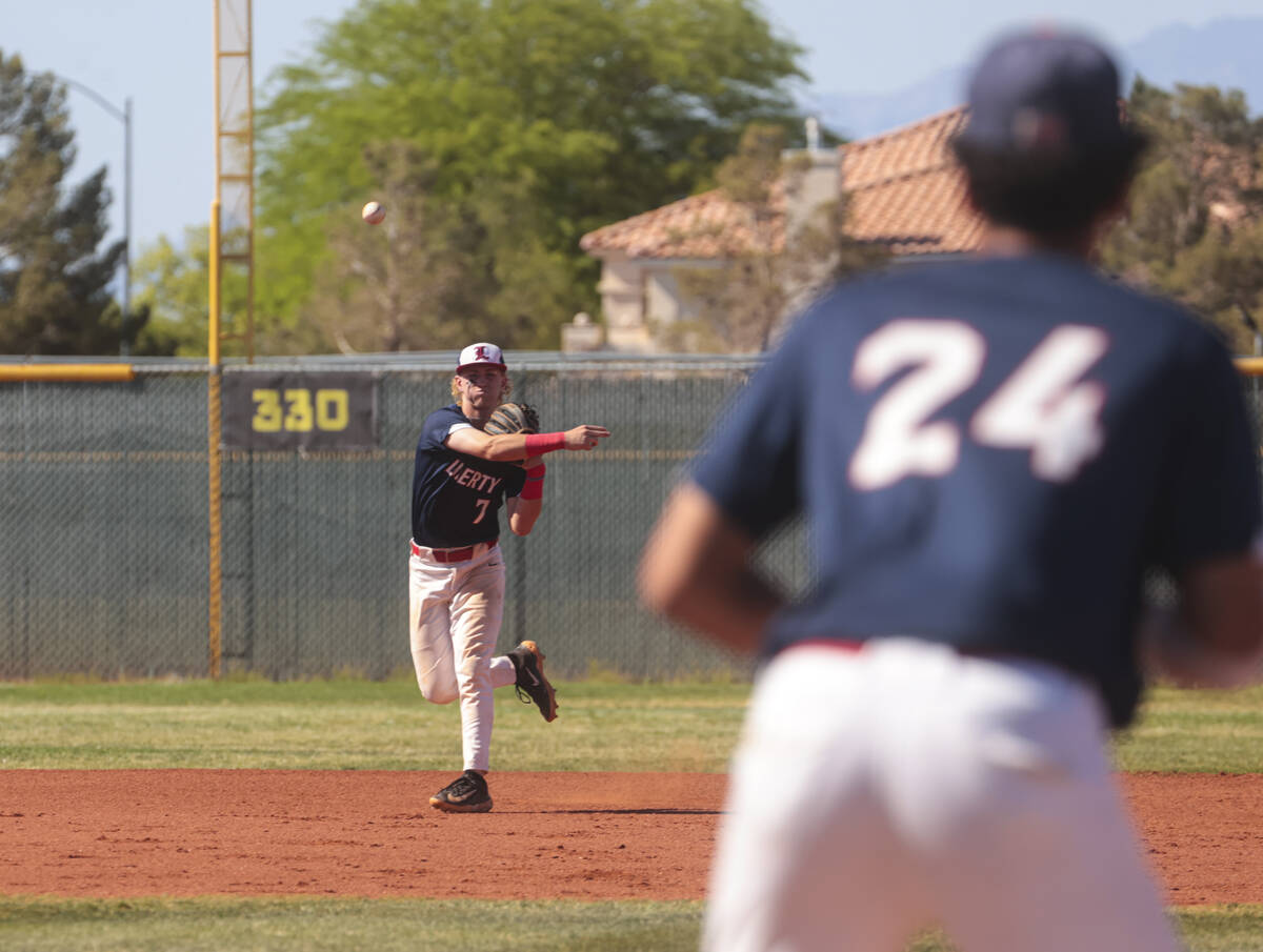 Liberty’s Konner Brown (7) throws to Shawn Mack (24) at first base during a baseball gam ...