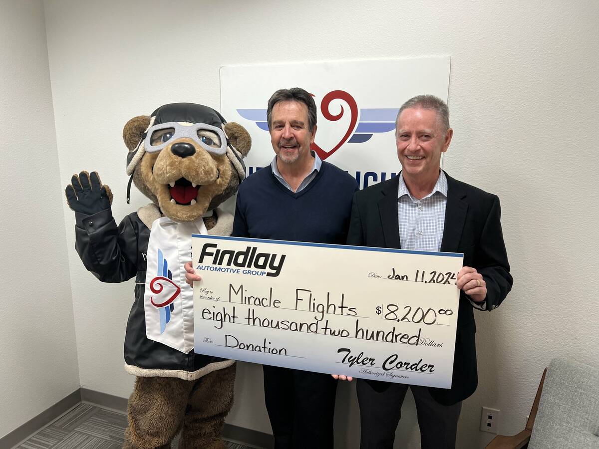 Caption: Miles the Bear, Miracle Flights’ mascot, Mark Brown, Miracle Flights CEO and Tyler C ...