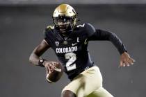 Colorado quarterback Shedeur Sanders (2) is pursued by Stanford linebacker Spencer Jorgensen (1 ...