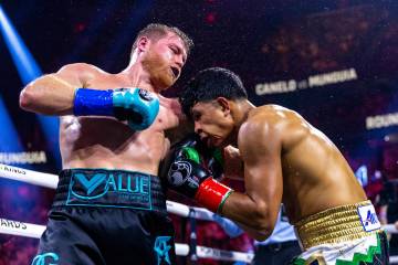 Canelo Alvarez connects with a punch to the ribs of Jaime Munguia sending him to the canvas dur ...