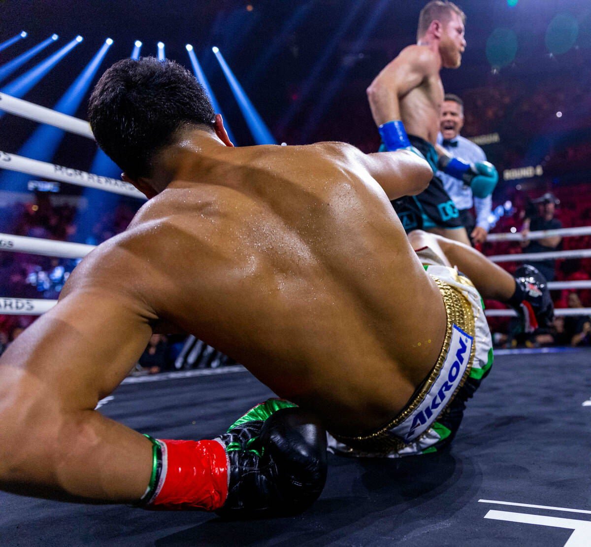 Canelo Alvarez connects with a punch to the ribs of Jaime Munguia sending him to the canvas dur ...