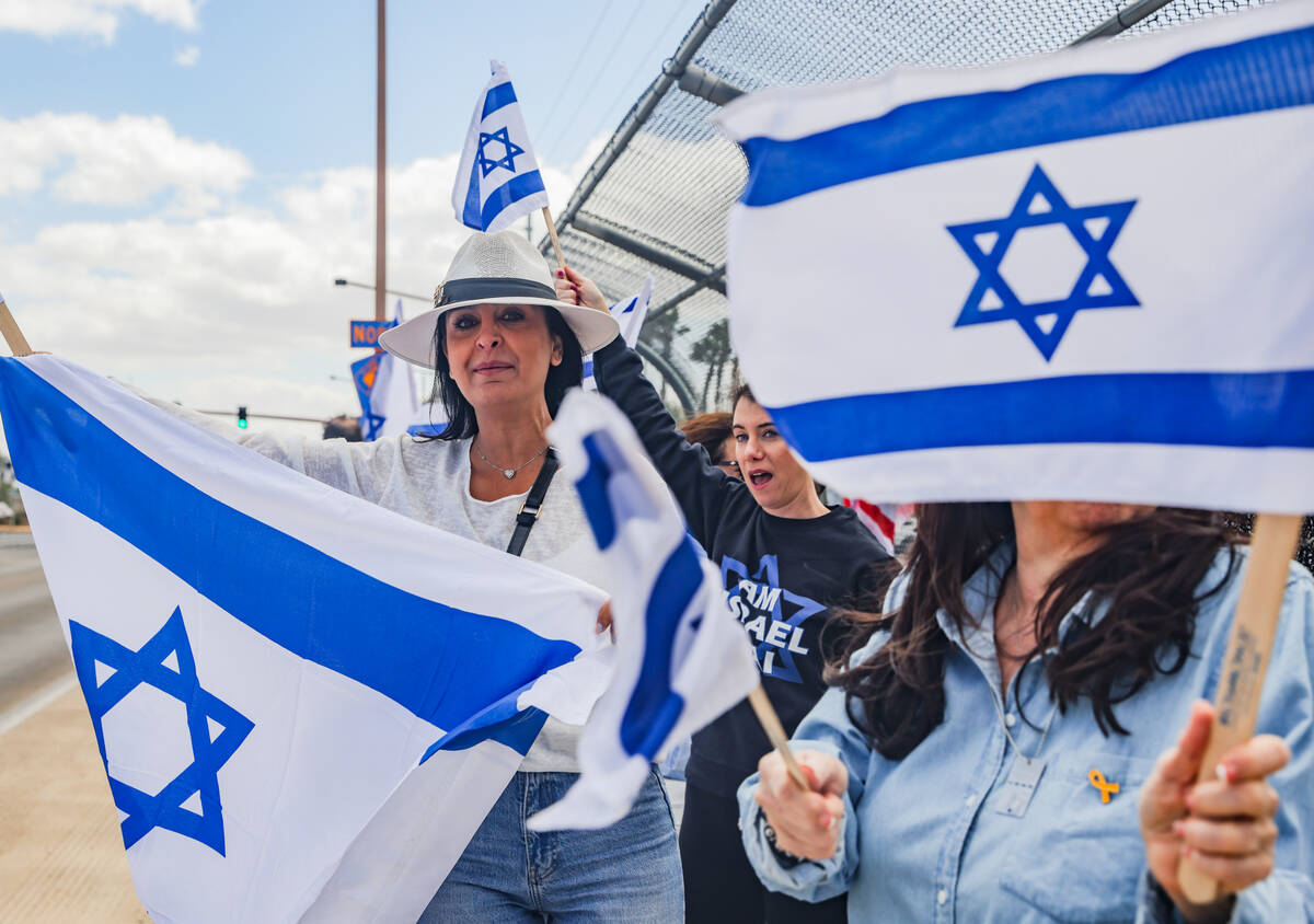 Pany Poura waves a flag with other participants on the Charleston bridge overpass on the 215 Be ...