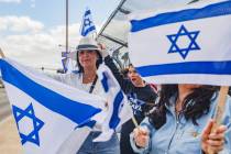 Pany Poura waves a flag with other participants on the Charleston bridge overpass on the 215 Be ...