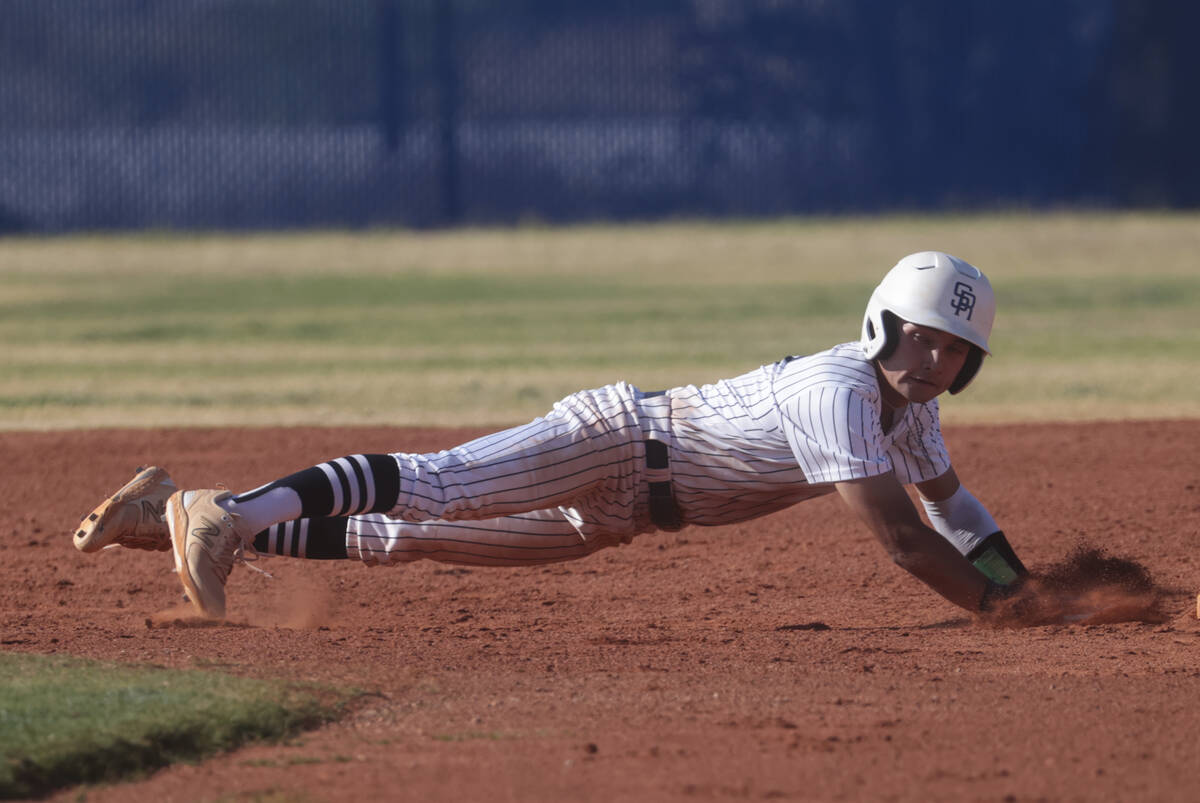 Shadow Ridge's Paul Wescott (2) dives back to second base while playing Green Valley in a high ...