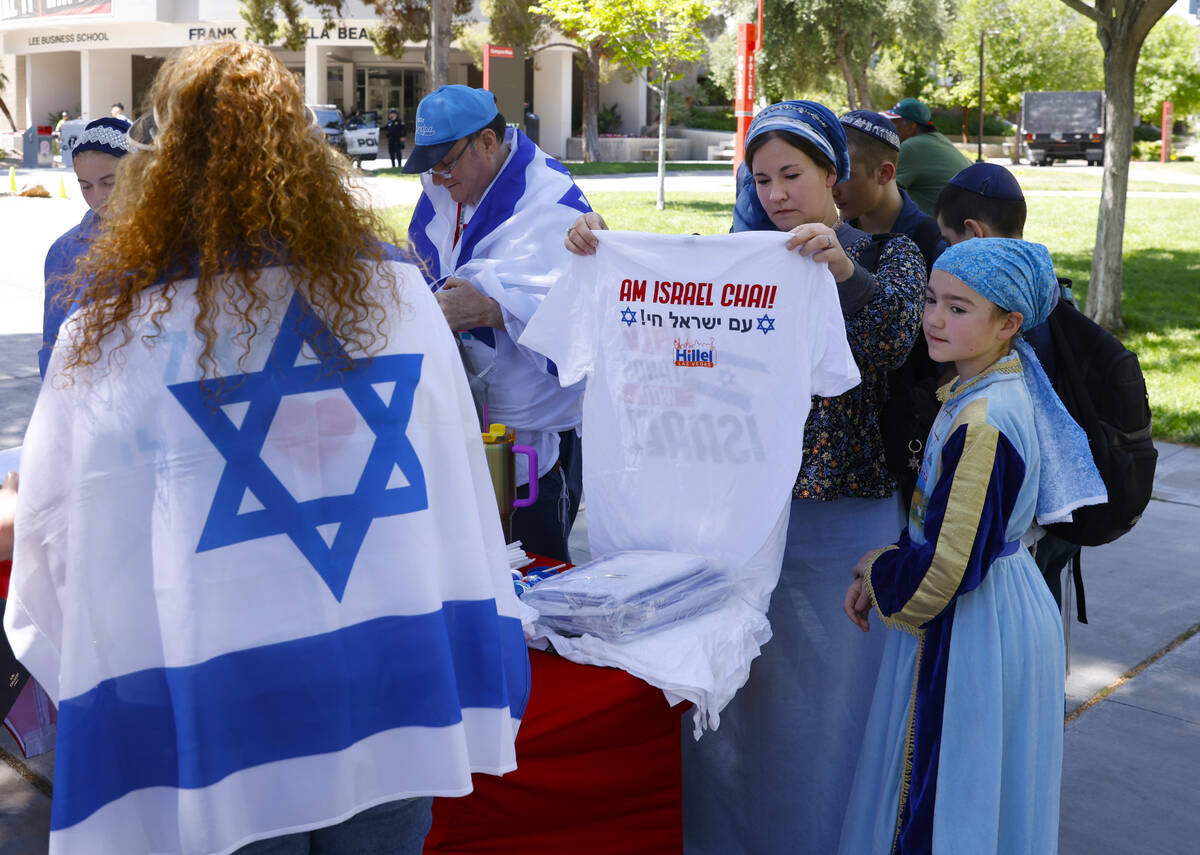 Lydia Netan, second right, checks out "We Stand With Israel" t-shirt as her daughter ...