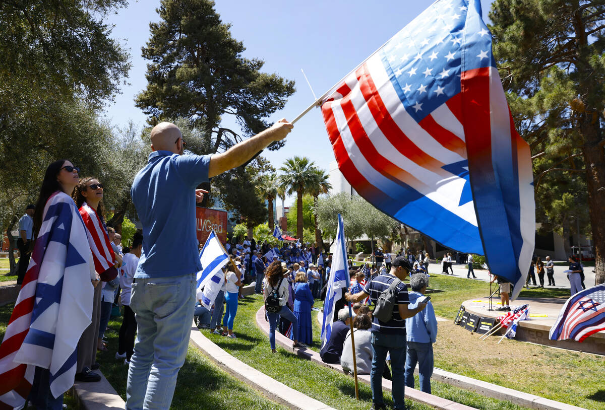 Ilan Sander waves American and Israeli flag during Stand Against Hate Rally, supporting Jewish ...