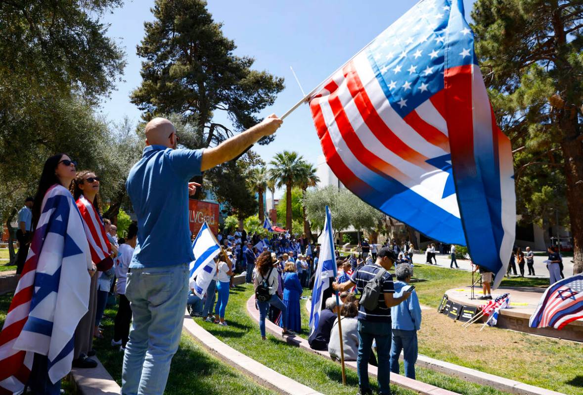 Ilan Sander waves American and Israeli flag during Stand Against Hate Rally, supporting Jewish ...