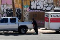 An unidentified man adjusts the rear end of his Nissan Frontier pickup and U-Haul trailer after ...