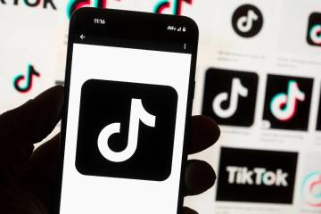 The TikTok logo is displayed on a mobile phone in front of a computer screen, Oct. 14, 2022, in ...