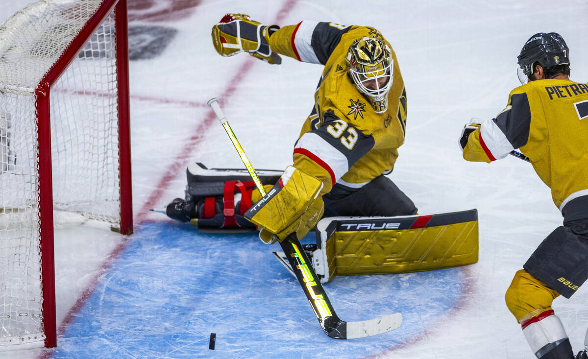 Golden Knights goaltender Adin Hill (33) pokes away a shot by the Dallas Stars during the secon ...