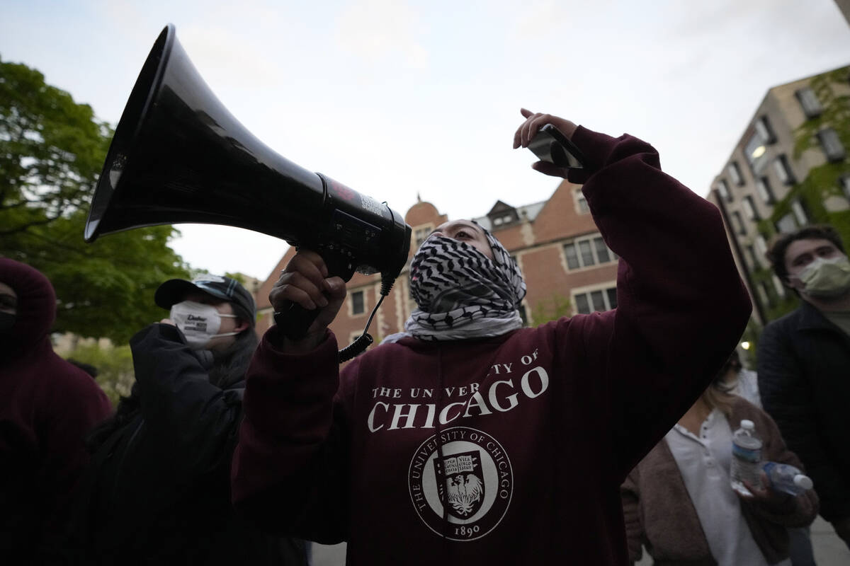 A pro-Palestinian protester leads chants at the university's police as they are kept from the u ...