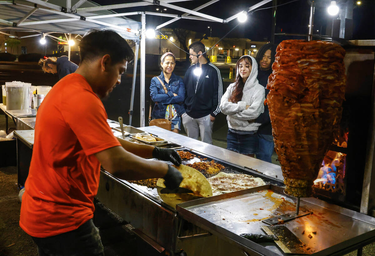 Daiyon Ranking and his girlfriend Katie Stoia, right, watch as Jaime Melendez prepares their bu ...