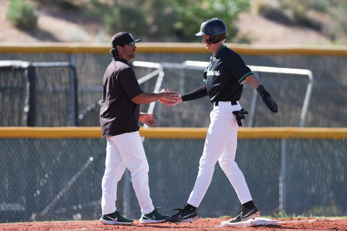 Palo Verde’s Ethan Clauss high fives head coach Dustin Romero as he reaches third base d ...