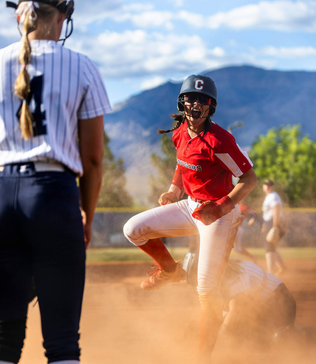 Coronado runner Bailey Goldberg (1) celebrates a safe slide at home plate past Shadow Ridge cat ...