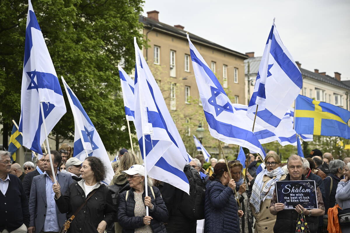 People carry Israeli and Swedish flags during a pro-Israel demonstration to pay tribute to Isra ...