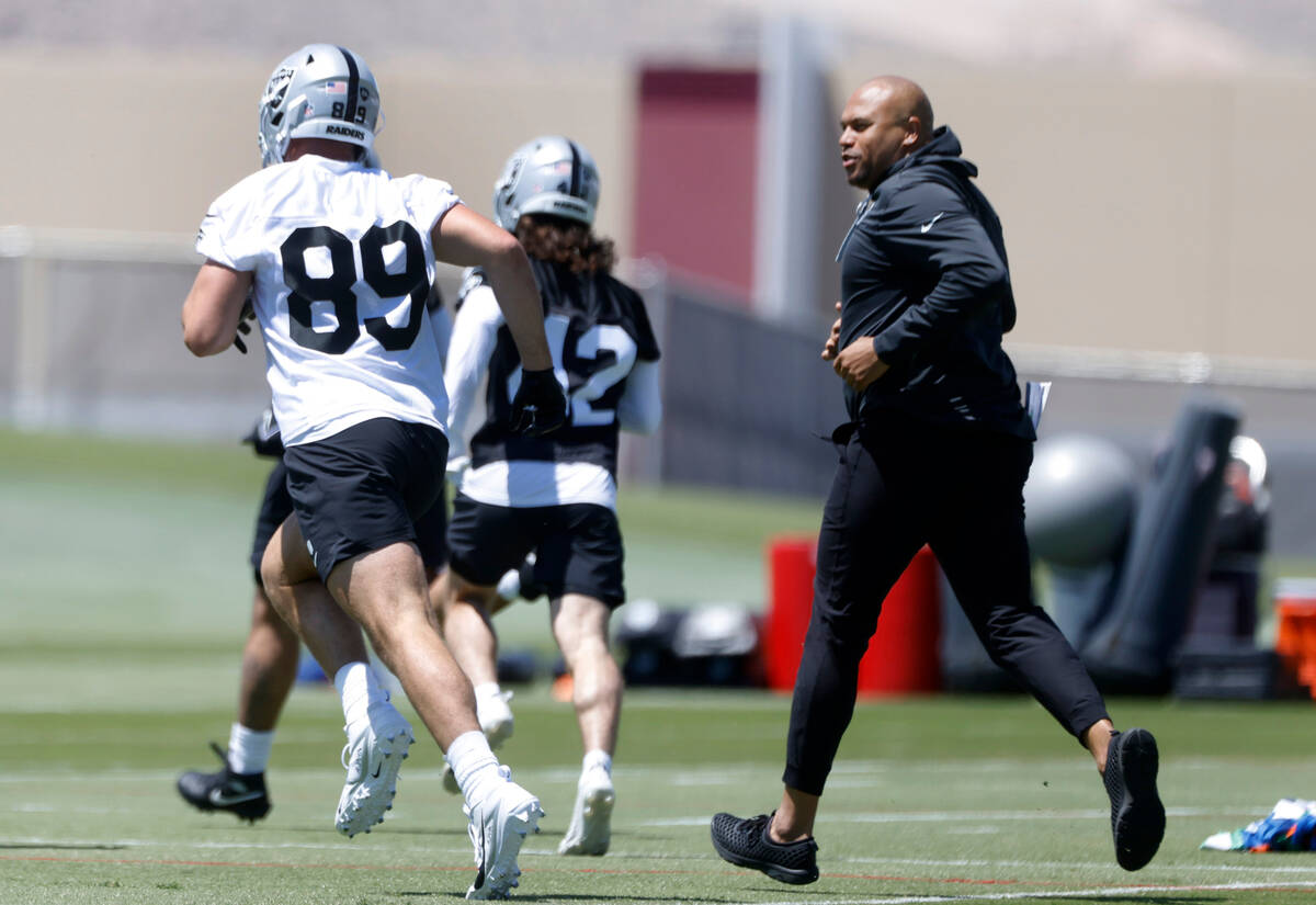 Raiders head coach Antonio Pierce, right, watches as rookie tight end Brock Bowers (89) takes t ...
