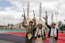 Houthi supporters raise their machine guns during a rally against the U.S.-led strikes against ...