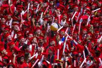 A beach ball is swatted about the group as graduates cheer and applaud by waving light sticks a ...