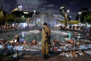 An Israeli soldier pays respect at a memorial for victims of the bloody Oct. 7, cross-border at ...