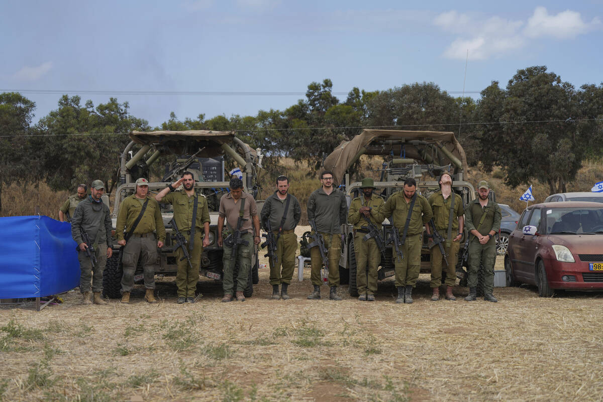 Israeli soldiers stand still as a siren marks the annual Memorial Day for fallen soldiers who d ...