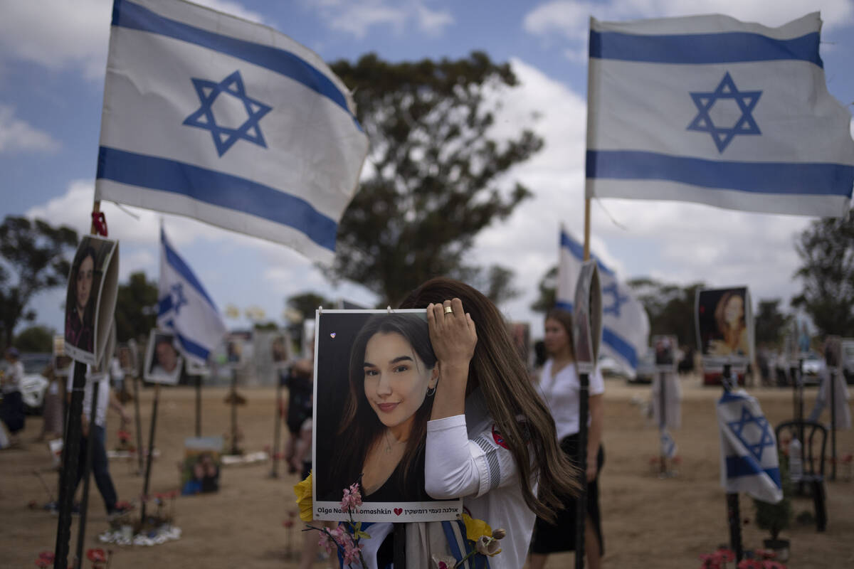 A woman touches a picture of a relative as she attends the celebrations of the Israel's annual ...