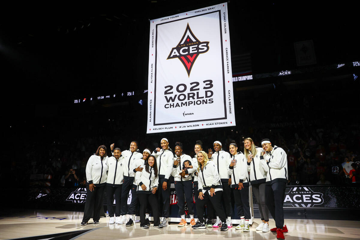 The Las Vegas Aces pose for a photo in front of their new banner to honor their 2023 WNBA Champ ...