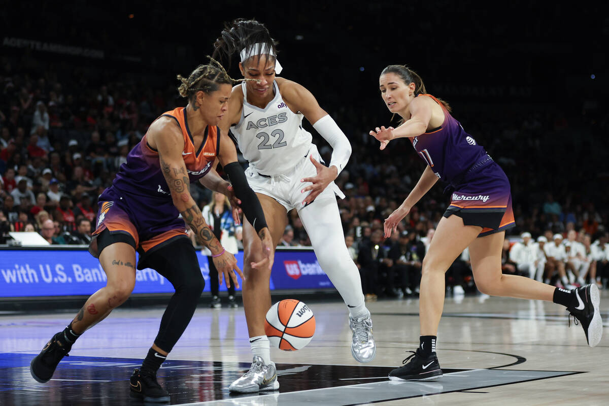 Las Vegas Aces center A'ja Wilson (22) and Phoenix Mercury guard Natasha Cloud (0) struggle for ...