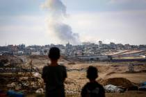 Boys watch smoke billowing during Israeli strikes east of Rafah in the southern Gaza Strip on M ...