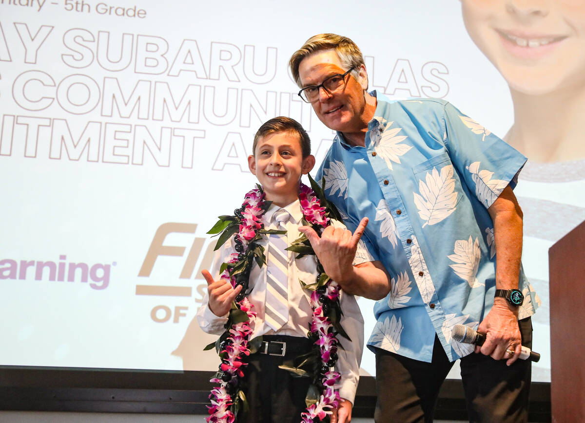 Burton Hughes, general manager of Suburu Las Vegas, poses for a photo with Carson Sheridan, win ...