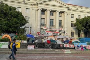 A man in a "California" jacket walks by the Pro-Palestine/Hamas encampment at Sproul ...