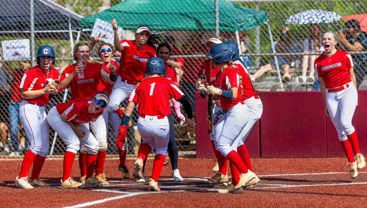 Coronado teammates cheer for a runner Bailey Goldberg (1) as she scores on a grand slam against ...