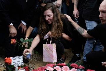Ricarda Louk places a candle on the grave of her daughter Shani Louk during her funeral in Srig ...