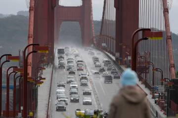 A person watches as traffic drives across the Golden Gate Bridge in Sausalito, Calif., on March ...