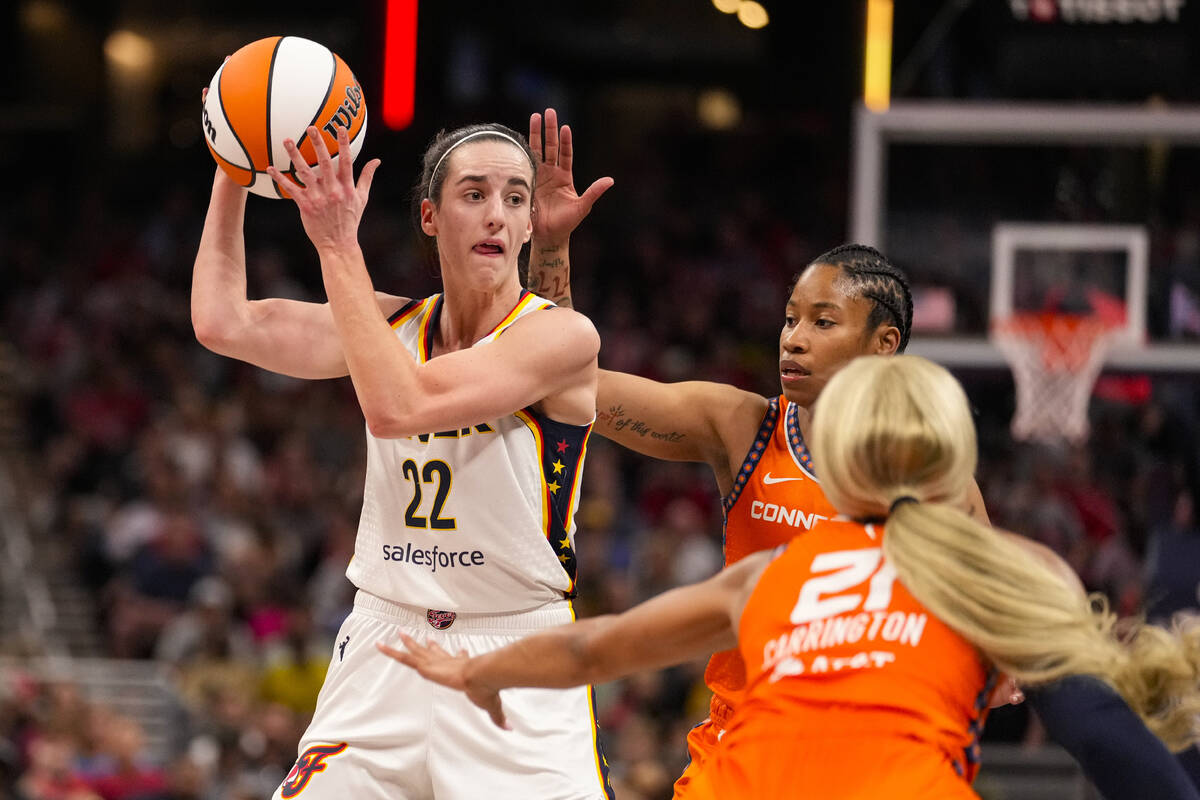 Indiana Fever guard Caitlin Clark (22) looks to pass over Connecticut Sun guard Tyasha Harris ( ...