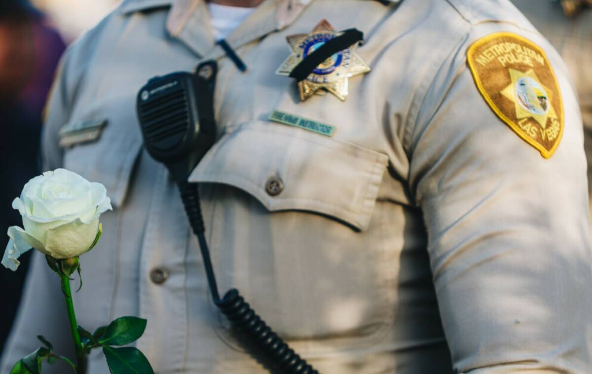 A police officer holds a white flower during the Southern Nevada Law Enforcement Memorial Cerem ...