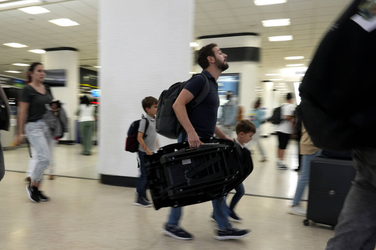 Travelers walk through the concourse at Miami International Airport ahead of the Memorial Day h ...