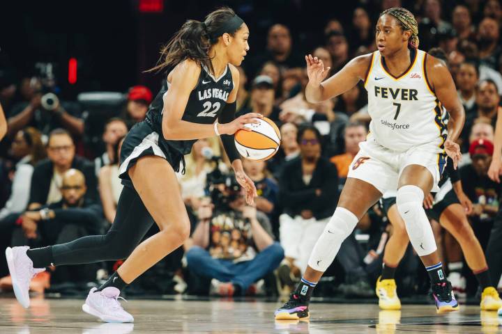 Aces center A'ja Wilson (22) moves the ball past Indiana Fever forward Aliyah Boston (7) during ...