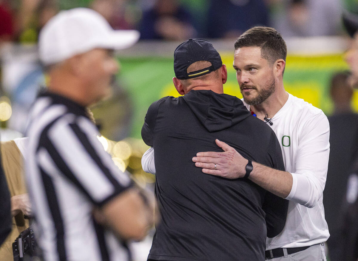 Washington Huskies head coach Kalen DeBoer hugs Oregon Ducks head coach Dan Lanning at midfield ...