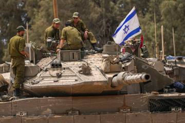 Israeli soldiers work on a tank near the Israeli-Gaza border, in southern Israel, Wednesday, Ma ...